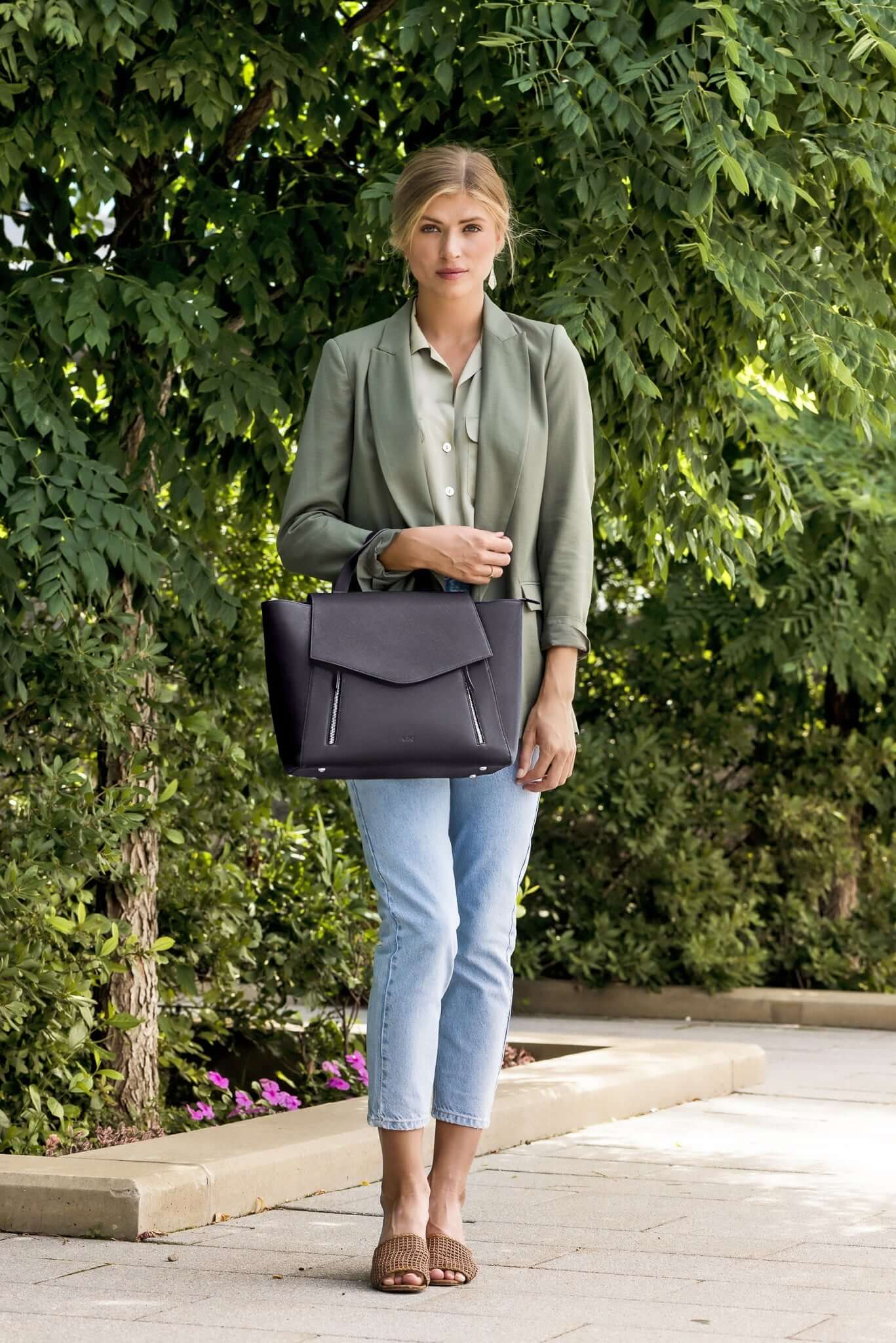 structured work bag. Woman carrying AGIKI Classic Black convertible leather laptop work bag for women while standing outdoors